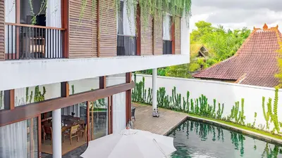 an external view of a house with a swimming pool at Villa Indrani in Canggu