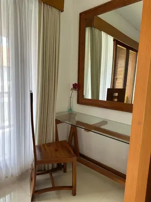 a mirror and a table and a chair in a room at Balcony Living Apartment in Seminyak