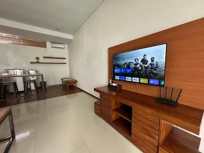 a living room with a flat screen tv on a wall at Balcony Living Apartment in Seminyak