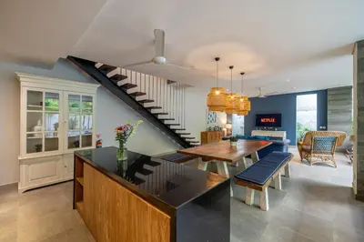 a kitchen with a dining table and a staircase at Villa Jekumah 2 in Seminyak