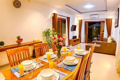 a dining room with a wooden table and chairs at Villa Caitlyn, Seminyak - Modern 3 Bedroom Villa with Private Pool! in Seminyak