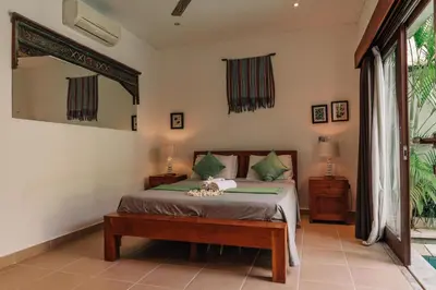 a bedroom with a bed and a large window at Charming Private Villa with Pool in Canggu