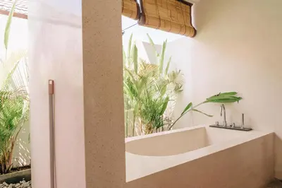 a bathroom with a sink and a window with plants at Charming Private Villa with Pool in Canggu