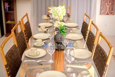 a long table with plates and glasses and flowers on it at Villa Ellen in Seminyak