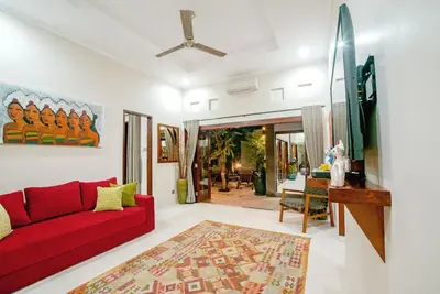 a living room with a red couch and a table at Villa Ellen in Seminyak