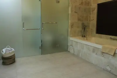 a bathroom with a shower and a tub and a sink at Villa Margaux in Seminyak