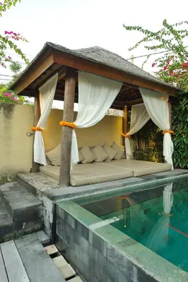 a bed sitting under a canopy next to a swimming pool at Elegant Villa Casabianca - Tropical Pool & Garden, Near Potato Head Beach Club! in Seminyak