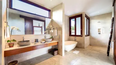 a bathroom with two sinks and a tub and a window at Casa Brio in Seminyak