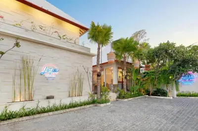 a house with palm trees next to a building at La Vie Villa Seminyak by Ini Vie Hospitality in Seminyak