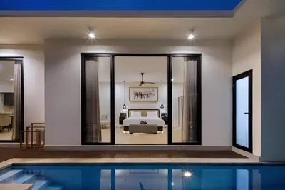 a bedroom with a bed and a swimming pool at The Grand Daha Luxury Villas in Seminyak