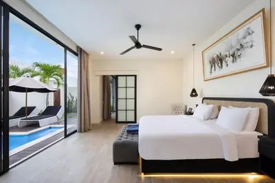 a bedroom with a bed and a patio with a pool at The Grand Daha Luxury Villas in Seminyak