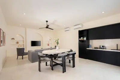 a living room with a table and a couch at The Grand Daha Luxury Villas in Seminyak