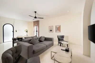 a living room with a couch and a table and chairs at The Grand Daha Luxury Villas in Seminyak