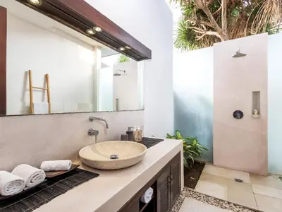 a bathroom with a sink and a mirror at Villa Arte by Villa Finder in Seminyak