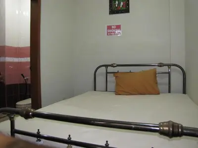a bed with a orange pillow on it in a room at Diva House in Denpasar