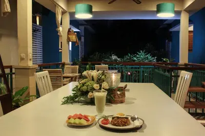 a table with two plates of food and a drink at The Green Zhurga Suite Seminyak in Kerobokan