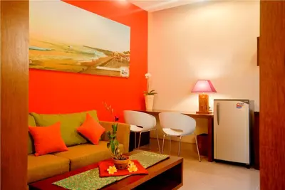 a living room with a couch and a table at The Green Zhurga Suite Seminyak in Kerobokan