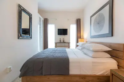 a bedroom with a large bed and a mirror at Beach Melati Apartments in Legian