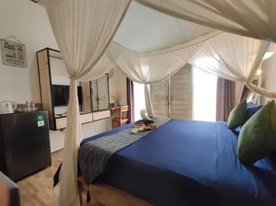a bedroom with a blue bed with a canopy at Kubu Guest House in Seminyak