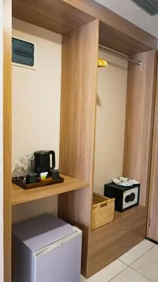 a kitchen with a cupboard with a microwave at Tusita Boutique Hotel in Kuta
