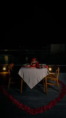 a table and two chairs in a dark room at Tusita Boutique Hotel in Kuta