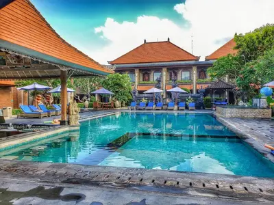 a swimming pool in front of a resort at Satriya Cottages in Kuta