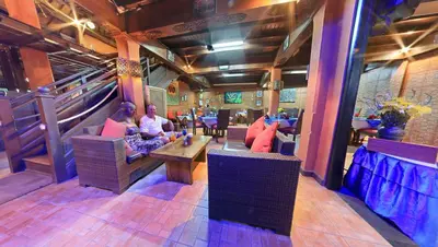 a group of people sitting in a restaurant at Satriya Cottages in Kuta