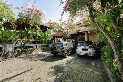 two cars parked in front of a house at Urbanview Hotel Rasa Sayang Inn Tanjung Benoa Bali in Nusa Dua
