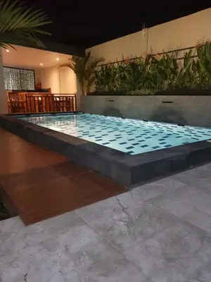 a large pool with blue tiles on the floor at Praba Guesthouse in Kuta