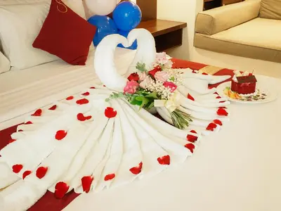 a wedding cake with swans and roses on a bed at Samaja Beachside Villas in Seminyak
