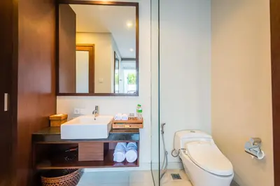 a bathroom with a sink and a toilet and a mirror at Samaja Beachside Villas in Seminyak