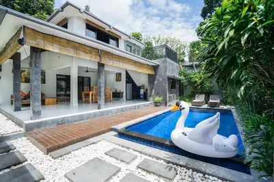 two swans in a swimming pool next to a house at Samaja Beachside Villas in Seminyak