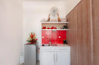 a kitchen with a sink and a red wall at Bali Ginger Suites & Villa in Seminyak