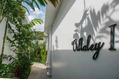 a sign on the side of a building with palm trees at Villa Ley Double Six by Best Deals Asia Hospitality in Seminyak