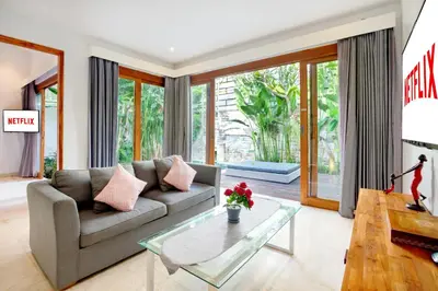 a living room with a couch and a glass table at The Jimbaran Villa by Ini Vie Hospitality in Jimbaran