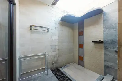 a bathroom with a shower with a glass door at Lembayung Sari Homestay in Denpasar