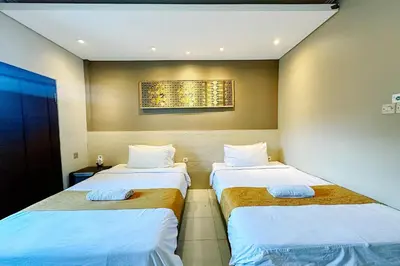 two beds in a hotel room with two bedsvisor at Lembayung Sari Homestay in Denpasar
