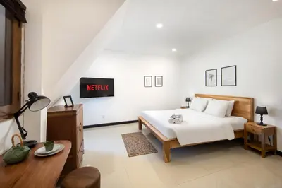a bedroom with a bed and a desk and a tv at Best Location 7 Bed, 7,5 Bath Pool Villa, near beach in Kuta