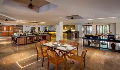 a dining room with a table and some chairs at The Magani Hotel and Spa in Legian