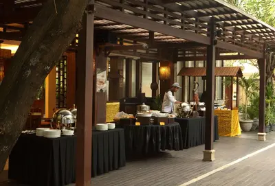a kitchen with people preparing food on tables at Best Western Kuta Villa in Kuta