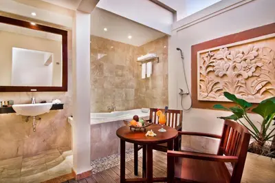 a bathroom with a table and a sink and a tub at Best Western Kuta Villa in Kuta