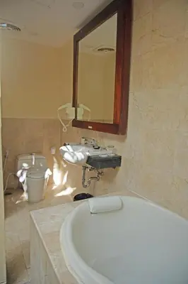 a bathroom with a sink and a bath tub at Best Western Kuta Villa in Kuta