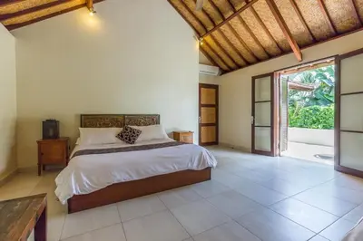 a bedroom with a bed and a large window at Rumi Villas in Seminyak