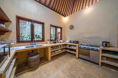 a kitchen with a counter with a sink and a stove at Rumi Villas in Seminyak
