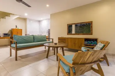 a living room with a couch and a table and chairs at Rumi Villas in Seminyak