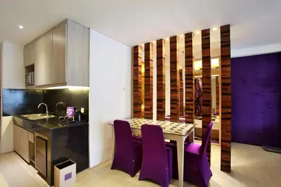 a kitchen and dining room with a table and purple chairs at Grand Mega Resort & Spa Bali in Kuta