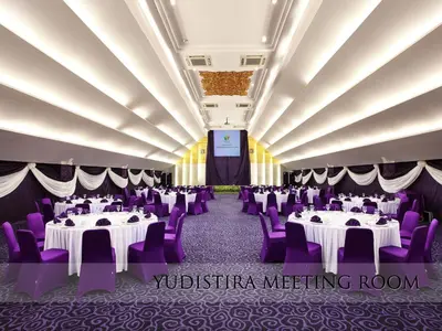 a banquet hall with white tables and purple chairs at Grand Mega Resort & Spa Bali in Kuta