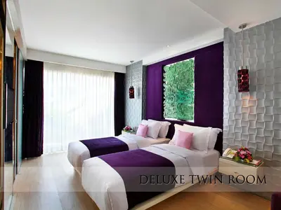 two beds in a hotel room with purple walls at Grand Mega Resort & Spa Bali in Kuta
