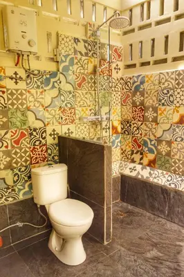 a bathroom with a toilet and a shower at Petit Tree in Seminyak