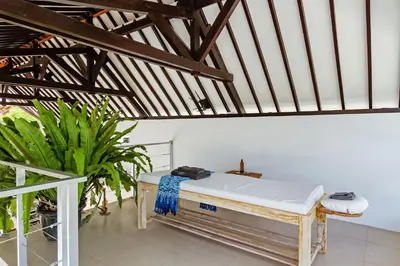 a bed in the middle of a room with plants at Villa Serasi in Canggu